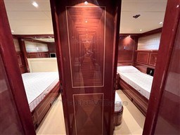 Luxurious interior of 2005 Mangusta 72 Open yacht with elegant wood paneling and twin beds.