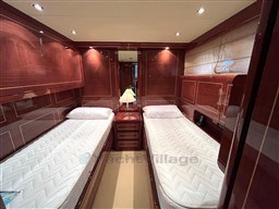 Luxurious twin cabin interior of 2005 Mangusta 72 Open yacht with wooden finishes.