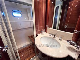 Luxurious bathroom in 2005 Mangusta 72 Open yacht with wooden accents and modern fixtures.