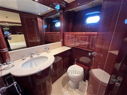Luxurious bathroom in a 2005 Mangusta 72 Open yacht with elegant wood finishes.