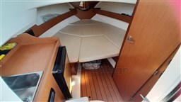 2008 Jeanneau Cap Camarat 755 WA cabin interior with bed, sink, and wooden flooring.
