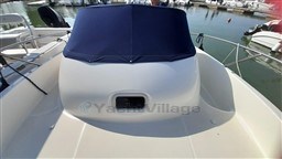 2008 Jeanneau Cap Camarat 755 WA boat with blue cover, docked in marina.