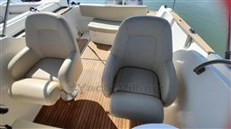 2008 Jeanneau Cap Camarat 755 WA boat interior with cushioned seats and wooden flooring.