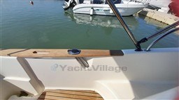 2008 Jeanneau Cap Camarat 755 WA boat interior with wooden accents, docked in marina.