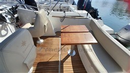 2008 Jeanneau Cap Camarat 755 WA boat interior with seating and wooden tables.