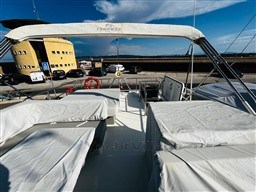 2019 Cranchi ECO Trawler 43 Long Distance docked, featuring covered seating and clear skies.