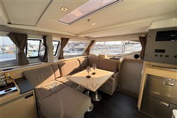 Luxurious interior of 2024 Fountaine Pajot Isla 40 catamaran with elegant seating and dining area.
