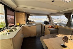 Luxurious interior of 2024 Fountaine Pajot Isla 40 catamaran with modern kitchen and seating area.