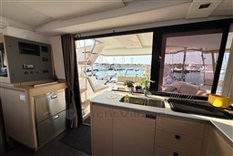 Interior view of 2024 Fountaine Pajot Isla 40 catamaran, featuring modern kitchen and marina backdrop.