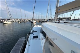 2024 Fountaine Pajot Isla 40 catamaran docked in a marina, surrounded by sailboats.