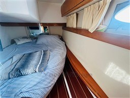 2005 Innovazione e Progetti Mira 43 cabin with cozy bed and wooden accents.