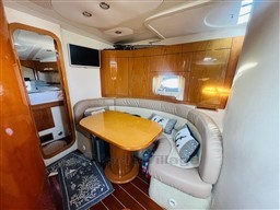 Luxurious 2005 Innovazione e Progetti Mira 43 yacht interior with cozy seating and elegant wood finishes.