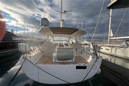 Sleek 2017 Hanse 588 yacht docked at marina under dramatic sky.