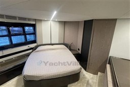 Luxurious bedroom interior of 2020 Azimut S6 yacht with modern design and large windows.