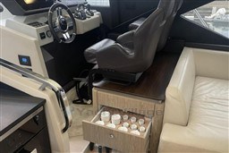 Interior of 2020 Azimut S6 yacht with helm, leather seating, and open drawer.
