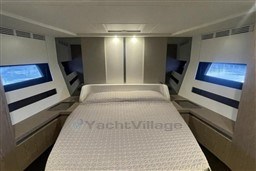Luxurious bedroom interior of 2020 Azimut S6 yacht with modern design and large windows.