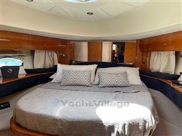 Luxurious cabin interior of 2002 Princess V65 yacht with cozy bedding.