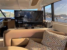 Luxurious interior of a 2002 Princess V65 yacht with TV and scenic ocean view.
