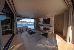 Luxurious interior of 2022 Sanlorenzo SD96 yacht with ocean view and elegant dining area.