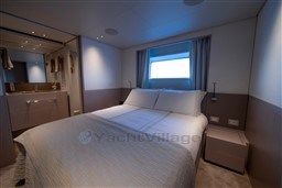Luxurious bedroom interior of 2022 Sanlorenzo SD96 yacht with modern design and cozy ambiance.