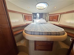 Luxurious cabin interior of a 2002 Rodman 38fly yacht with a cozy bed.
