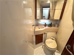 Compact bathroom in a 2002 Rodman 38fly yacht, featuring a toilet and sink.