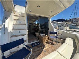 Rodman 38fly 2002 yacht interior with seating, stairs, and open cabin door.