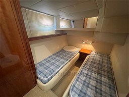 Twin cabin with plaid bedding in a 2002 Rodman 38fly yacht.