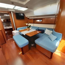 Interior of 2008 Beneteau Oceanis 43 yacht with blue seating and wooden finishes.