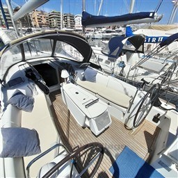 2008 Beneteau Oceanis 43 sailboat cockpit with dual steering wheels and seating in marina.