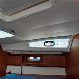 Interior view of 2008 Beneteau Oceanis 43 yacht cabin with window and wooden cabinetry.
