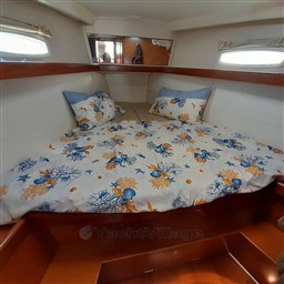 Cozy cabin interior of 2008 Beneteau Oceanis 43 with nautical-themed bedding.