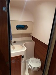 Compact bathroom in 2011 Mano Marine 28.50 Sport boat, featuring sink and toilet.