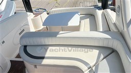 Luxurious seating area on a 2011 Mano Marine 28.50 Sport boat with a small table.