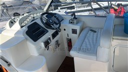 Cockpit of 2011 Mano Marine 28.50 Sport boat with steering wheel and seating.