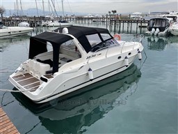 2011 Mano Marine 28.50 Sport boat docked in marina, featuring sleek design and black canopy.