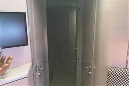 Interior view of a 2006 Azimut Atlantis 55 yacht, featuring a modern design with a TV and checkered chair.