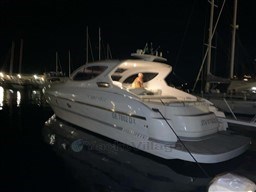 2004 Primatist G 50 Speedster yacht docked at night, illuminated in marina.
