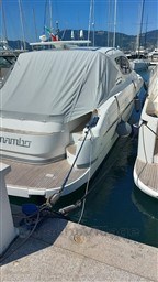 2004 Primatist G 50 Speedster yacht docked in marina, covered, with scenic mountain backdrop.