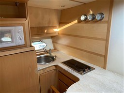 Compact kitchen in 2004 Primatist G 50 Speedster with stove, sink, and microwave.