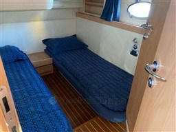 Cabin interior of 2004 Primatist G 50 Speedster with twin beds and wooden flooring.