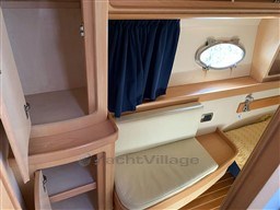Interior of 2004 Primatist G 50 Speedster yacht with wooden cabinetry and porthole window.