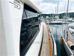 Azimut Magellano 50 yacht docked at marina, showcasing sleek design and wooden deck.