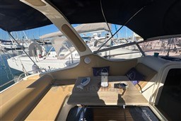 Cozy seating area on a 2007 Mano Marine 24.50 boat, docked at a marina.