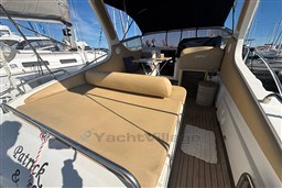 2007 Mano Marine 24.50 boat interior with beige seating and wooden flooring in a marina.