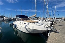 2007 Mano Marine 24.50 boat docked in marina under clear blue sky.