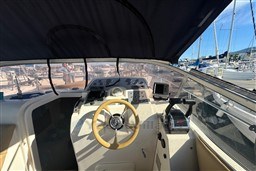 Cockpit view of 2007 Mano Marine 24.50 boat with steering wheel and controls.