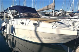 2007 Mano Marine 24.50 boat docked in marina, featuring sleek design and blue canopy.