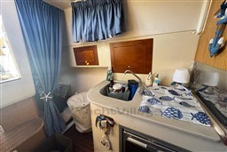 2007 Mano Marine 24.50 boat interior with kitchenette, sink, and nautical decor.