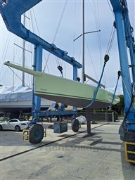 2024 Comuzzi Yachts C-32 Sport being lifted by a blue crane at a marina.